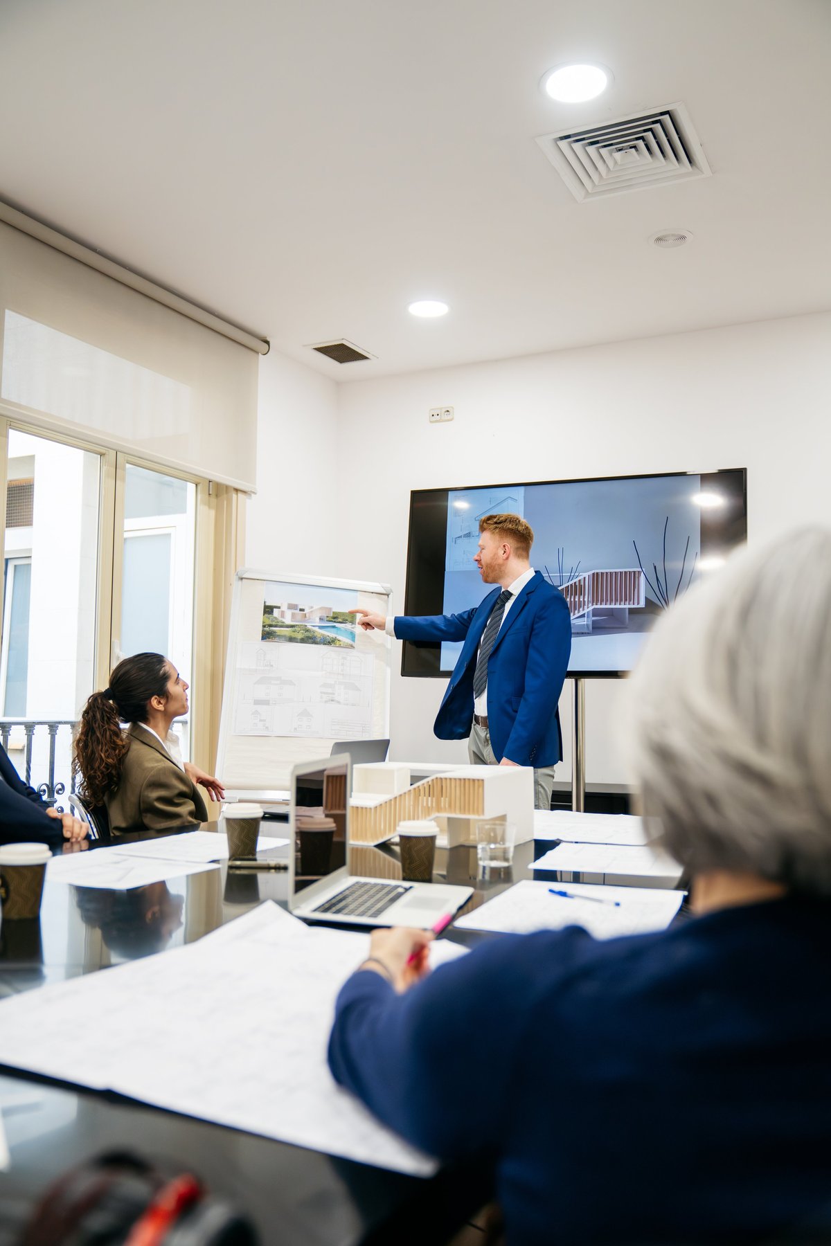Professionals collaborating over project documents and plans in a modern office